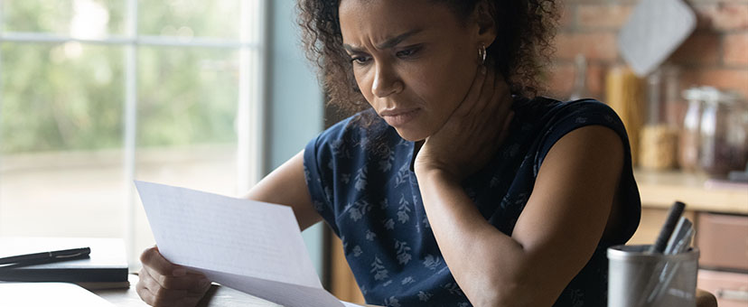 Woman reading paper looks stressed